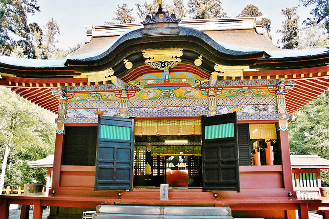 鮮やかな漆塗りの拝殿の写真